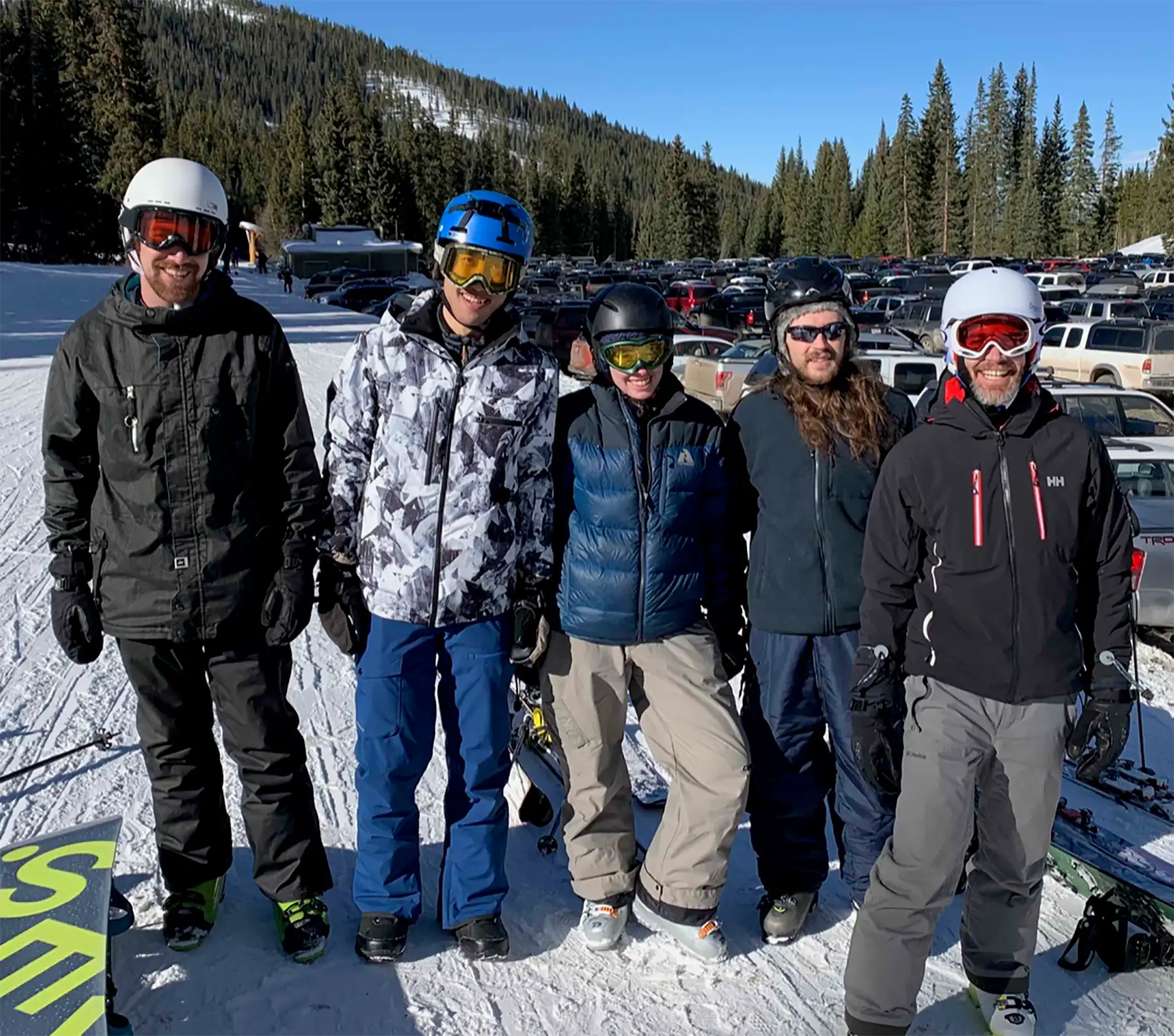 Disharoon, Neeves, and three fellow researchers dressed in snowboarding gear at a snowboarding hill.