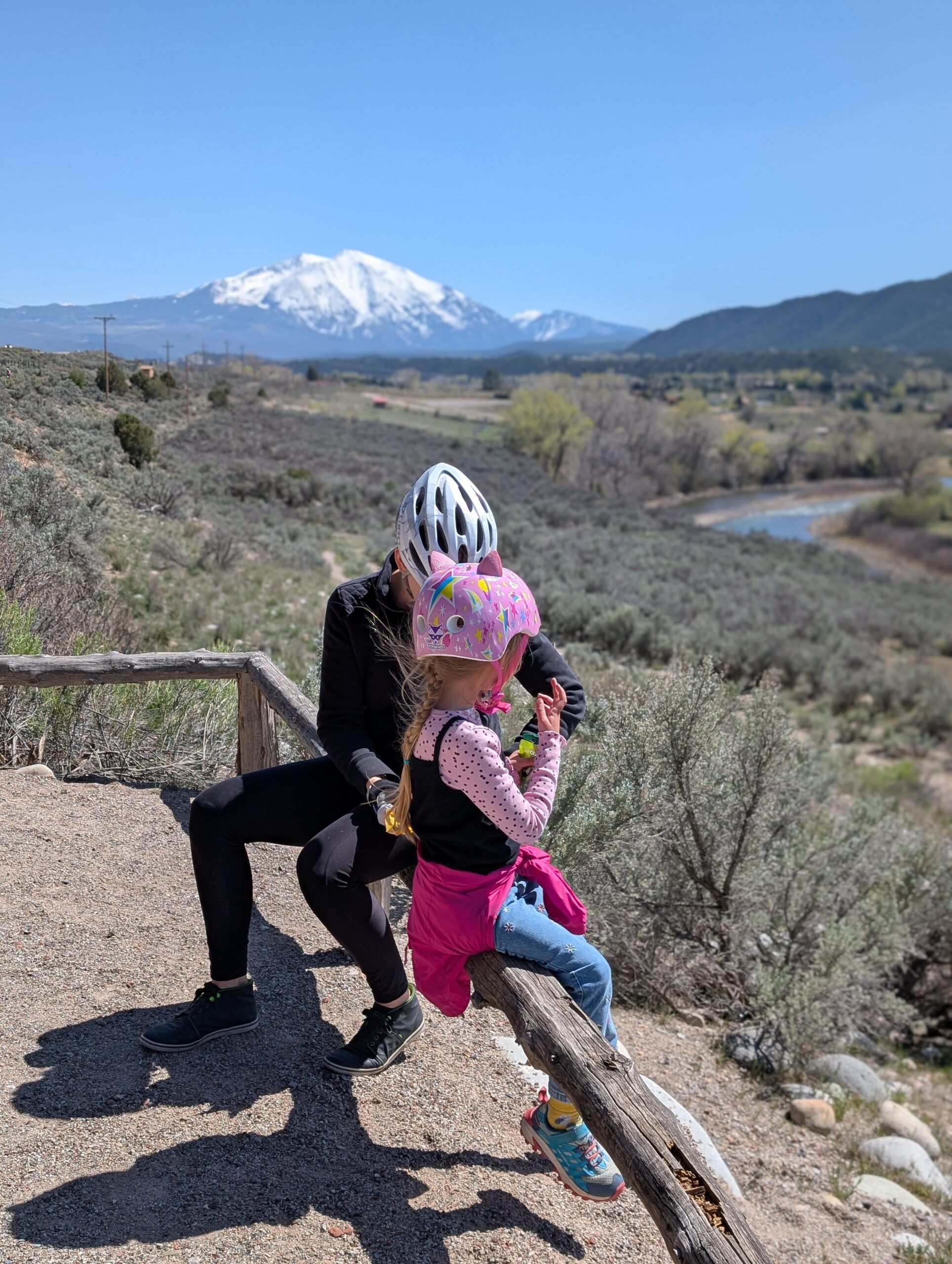 Zach Higgins and family sitting on a bench overlooking Mount Sopris in Colorado.